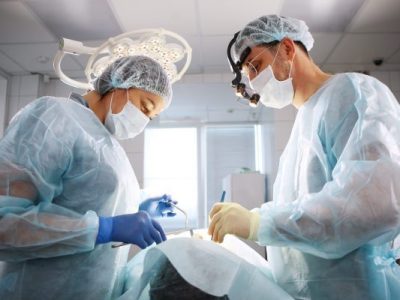 Dentysta Rzeszów wykonujący zabieg chirurgiczny na pacjencie.